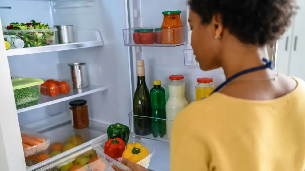 Une femme qui regarde de la nourriture dans un réfrigérateur