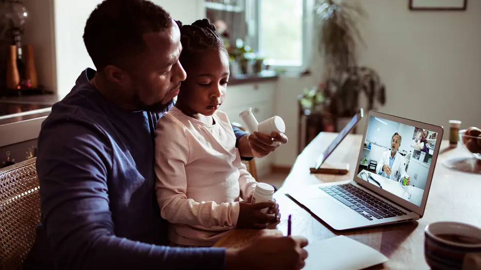 Un père et sa fille assistent à un rendez-vous médical virtuel.