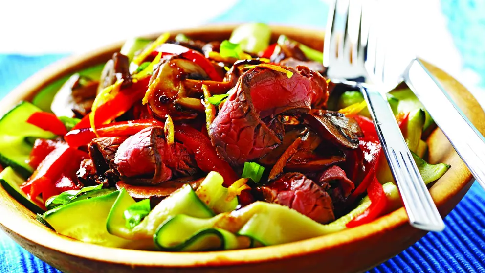 Tranches de bœuf, courgettes et poivrons rouges dans un bol