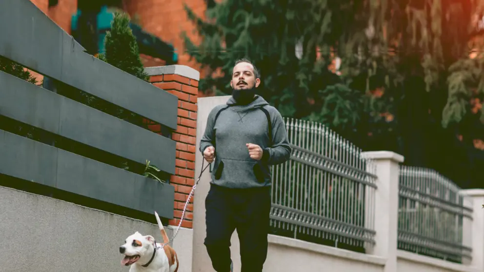 Un homme qui court avec son chien