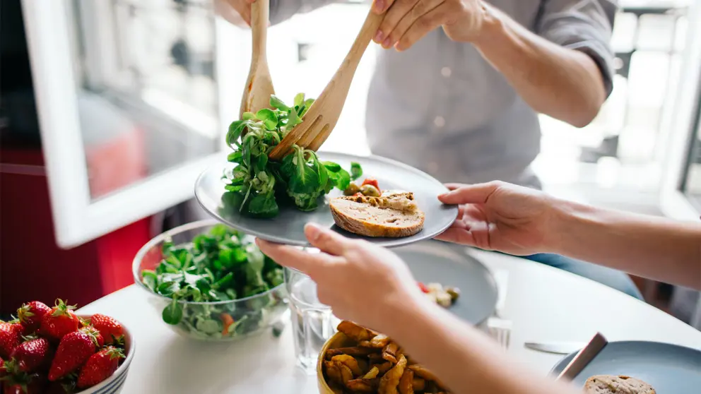 Une personne servant une salade de légumes