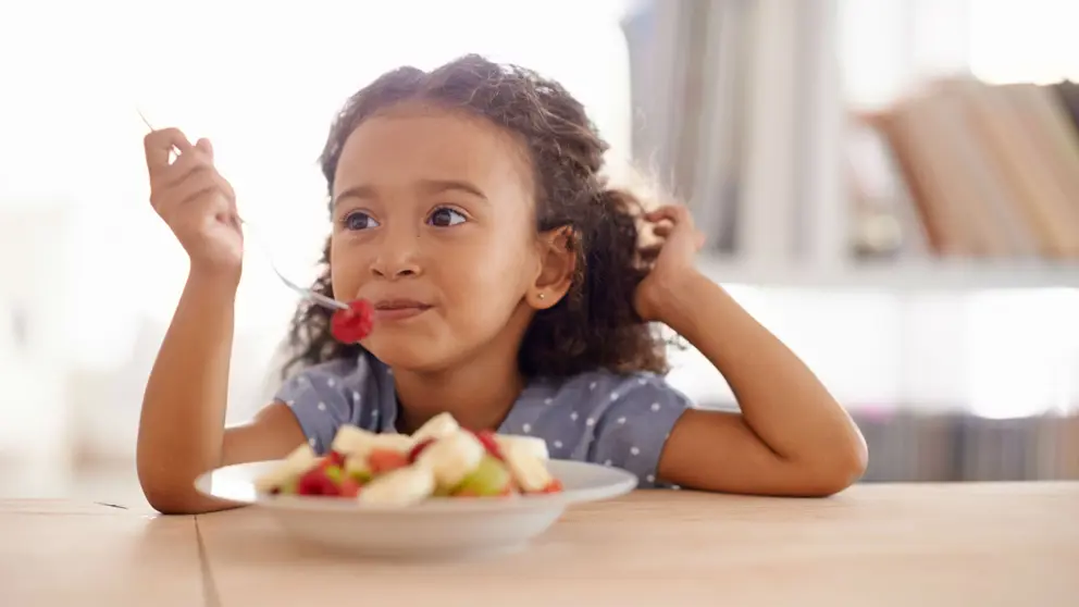 Fille de manger une salade de fruits