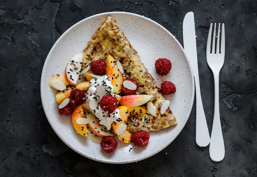 Une omelette et des fruits dans une assiette