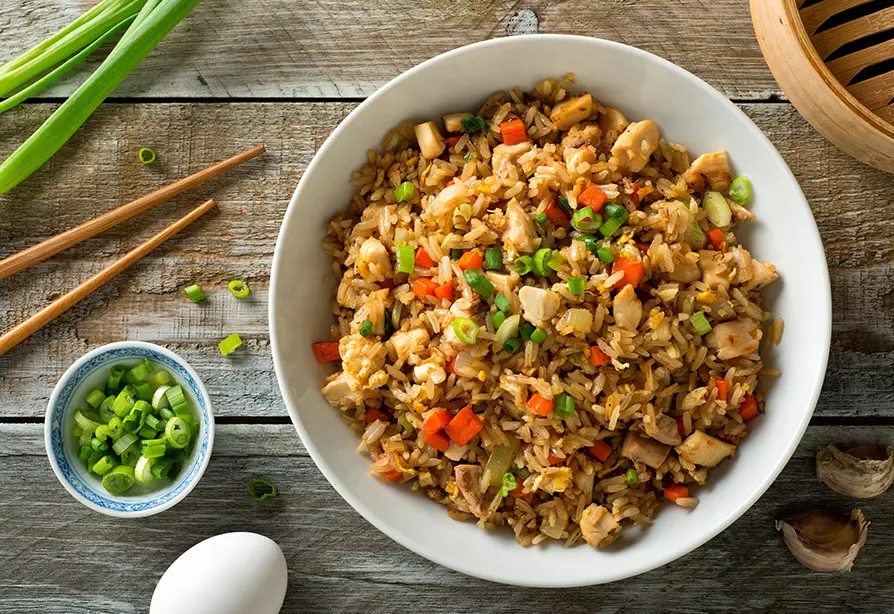 Bol de riz frit au poulet sur une table