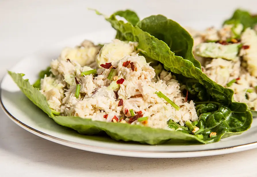 De la salade de thon servie sur des feuilles de laitue dans une assiette