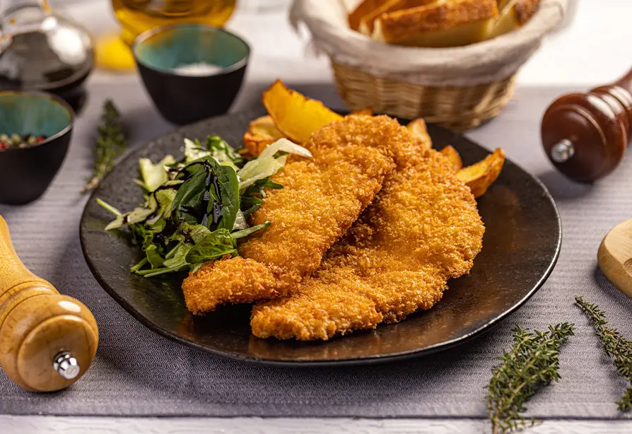 Lanières de dinde panées accompagnées de légumes dans une assiette