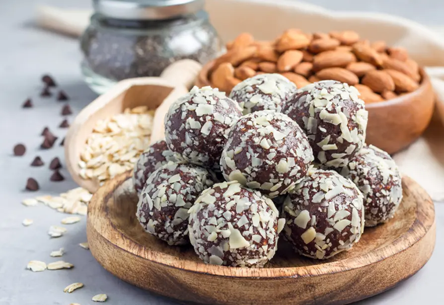 Des bouchées au chocolat et aux amandes accompagnés d’amandes, de pépites de chocolat et de flocons d’avoine.