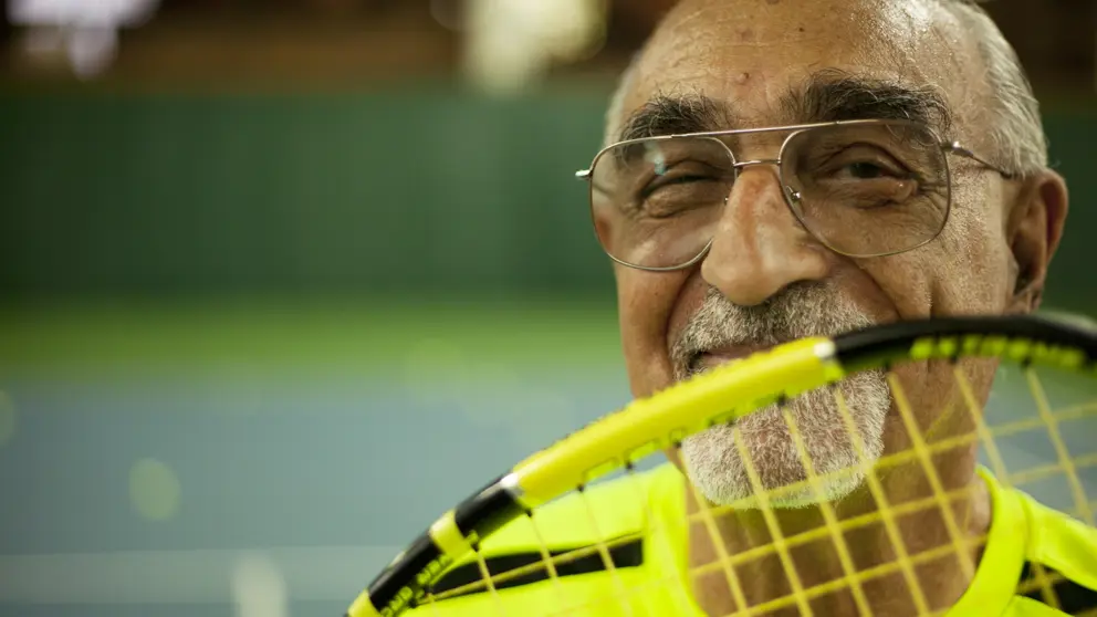 Marco smiling with tennis racquet